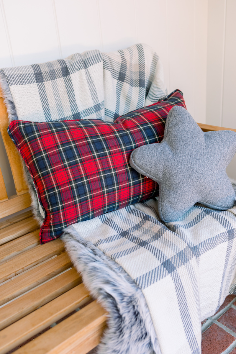 Neutral plaid throw and pillow on porch bench