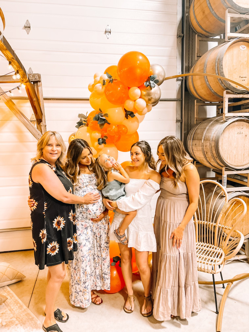 Family in wine cellar in front of balloon garland
