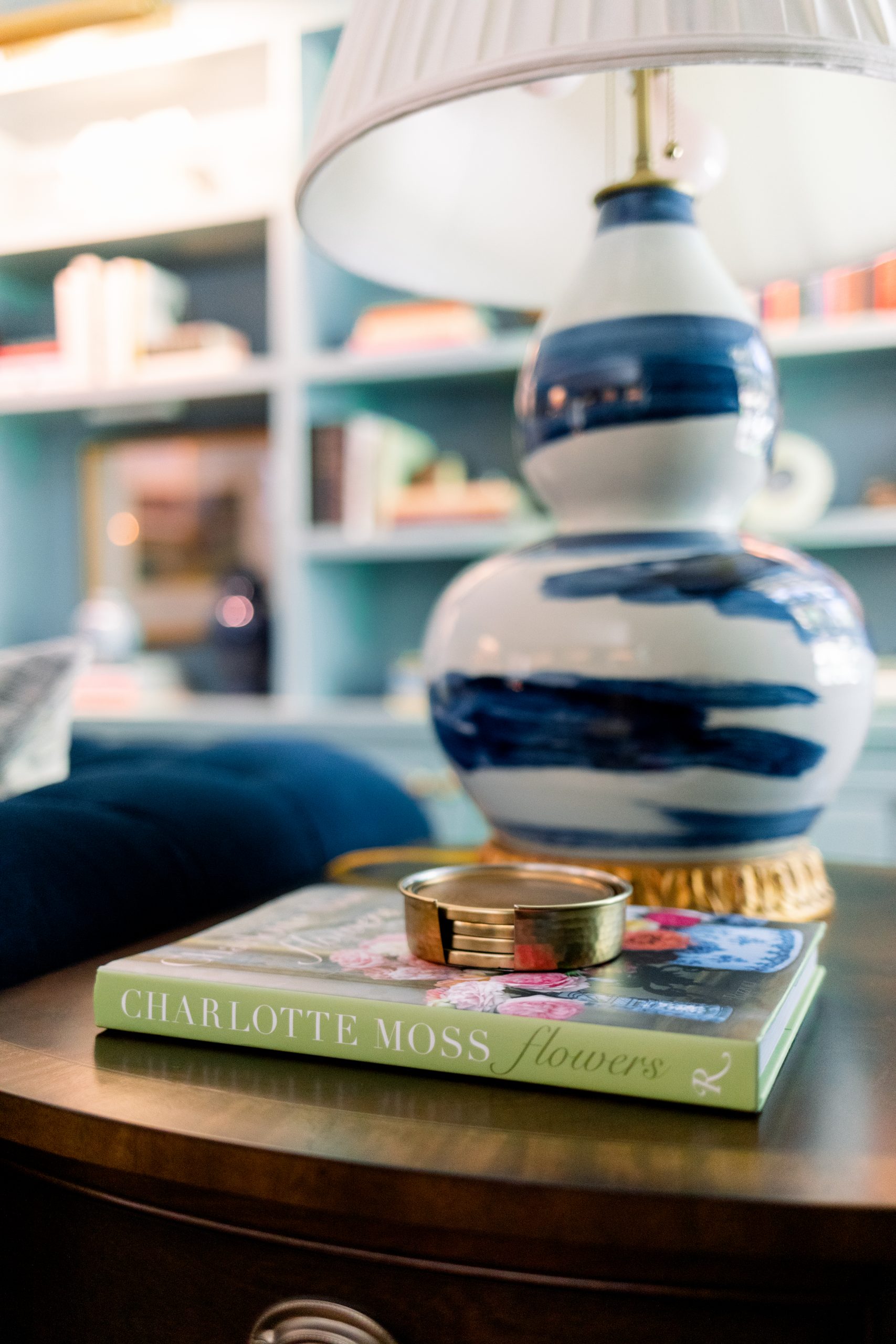 Blue and white lamp on side table with book