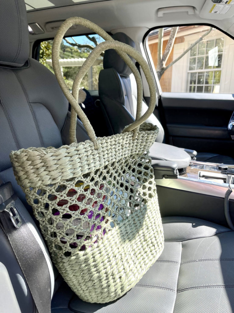Straw shopping bag sitting in front seat of car