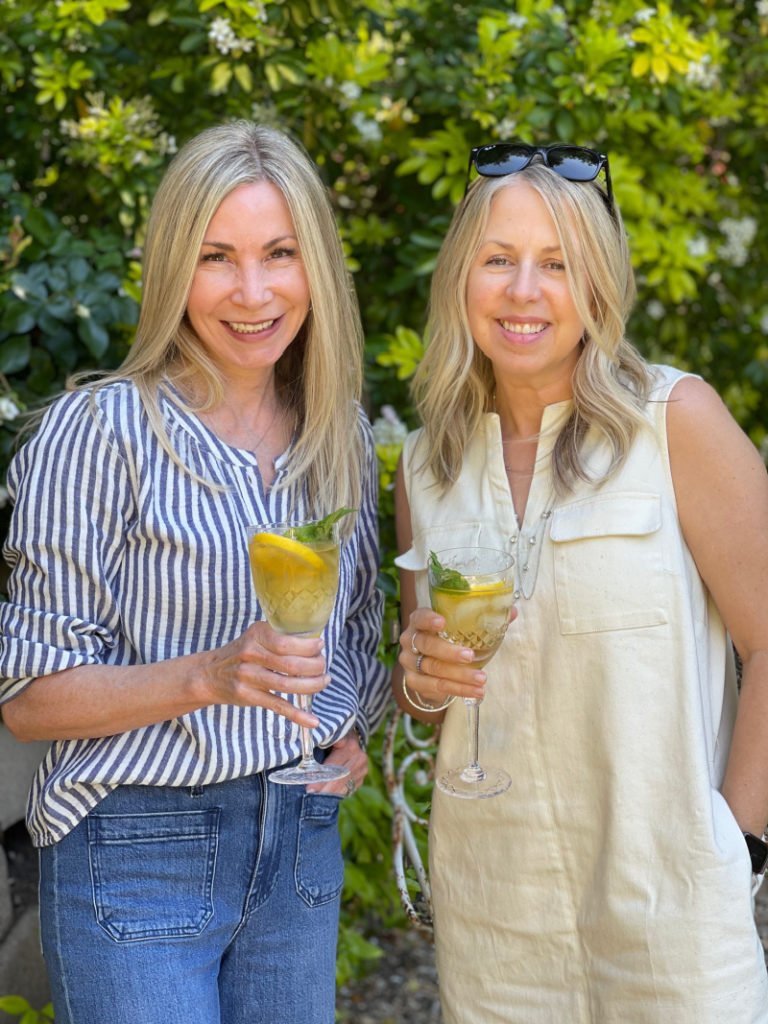 Two women holding drinks in the garden