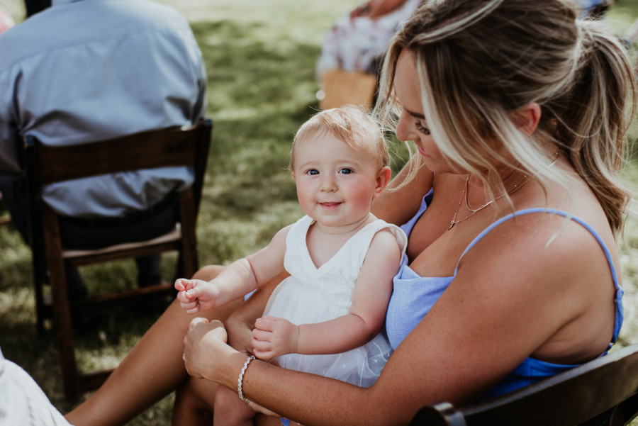 Baby in woman's lap at wedding
