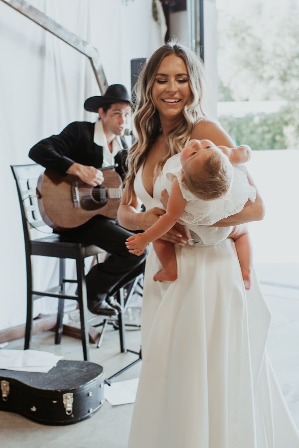 Bride and baby dancing to musician