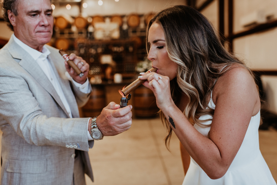 Wedding guest lighting cigar for bride