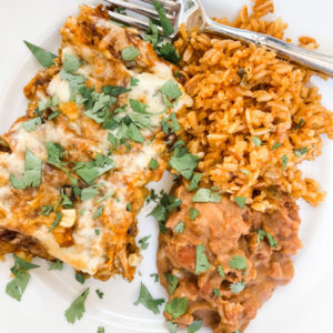 Chicken Enchiladas on plate with rice and beans