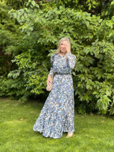 Woman in dress standing in garden.