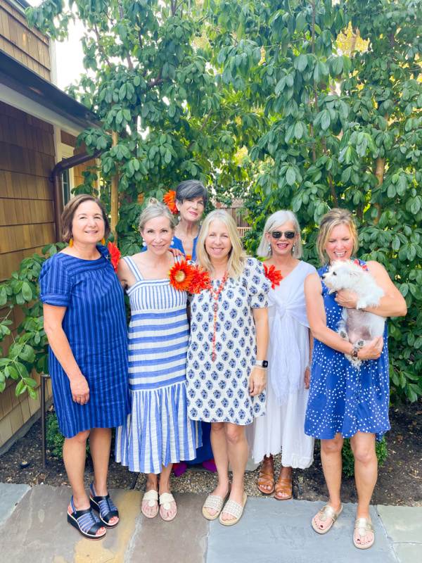 Six women standing in garden with dog.