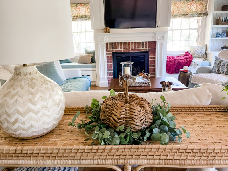 Console table with eucalyptus wreath and woven pumpkin.
