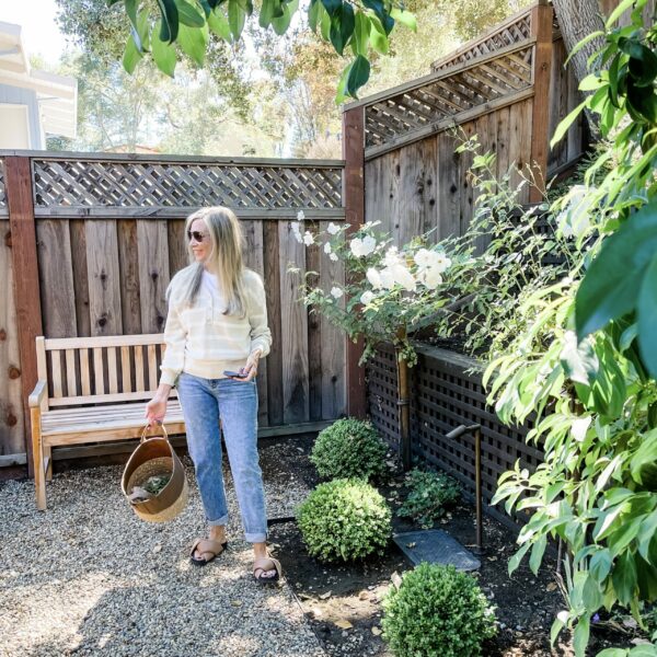 Woman standing in her garden with pruners.