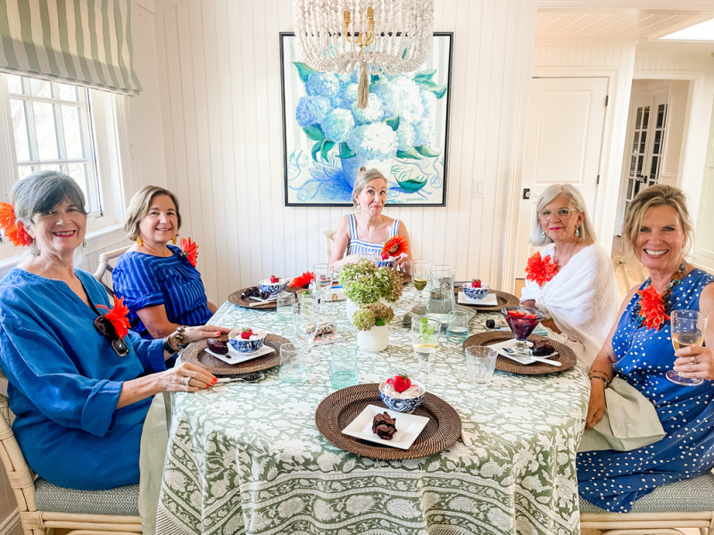 Five women sitting at table celebrating birthday.