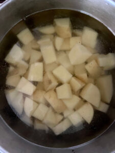 Cubed potatoes in a pan of salted water.