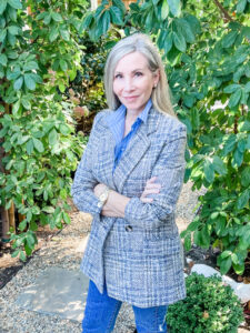 Woman in striped shirt and plaid blazer in the garden.