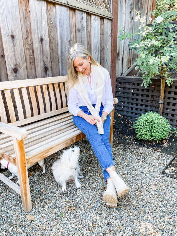 Woman on garden bench with white dog wearing Steve Madden ankle boots.