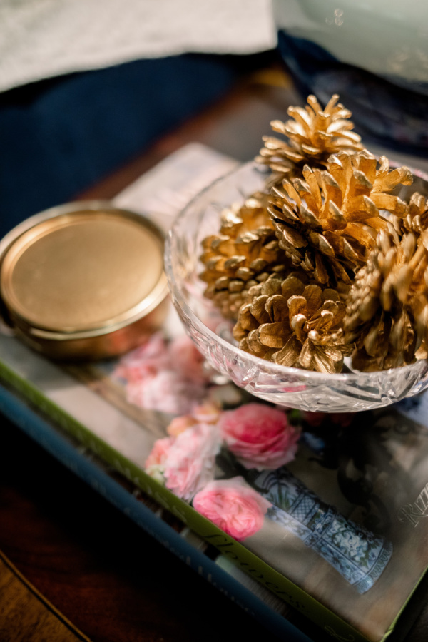 Crystal compote filled with gold pinecones.