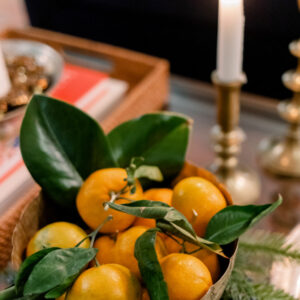 Aged brass compote dish filled with stemmed oranges.