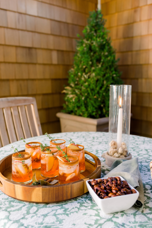 Tray of Apple Cider Aperol Spritz and bowl of roasted nuts.