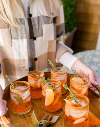Woman carrying tray of Apple Cider Aperol Spritz.