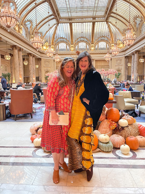 Women standing in front of pumpkin display at Palace Hotel Garden Court.