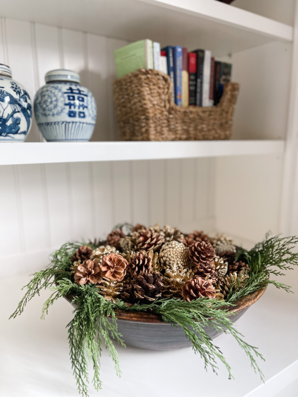 Bowl of greenery and pinecones.