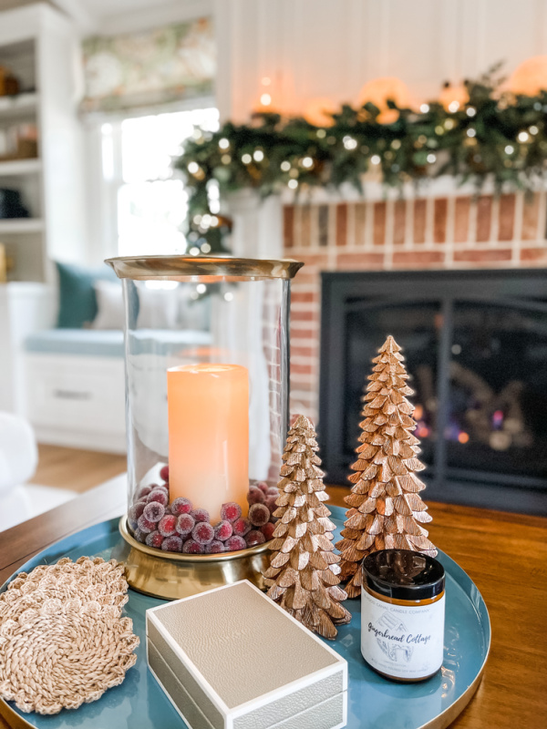 Christmas coffee table vignette with mantle in background.