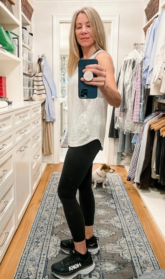 woman taking selfie in closet wearing workout outfit.
