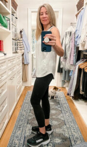 Woman taking closet selfie in workout outfit.
