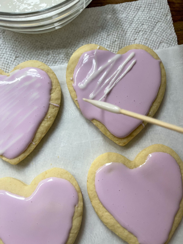Heart shaped cookie being decorated.