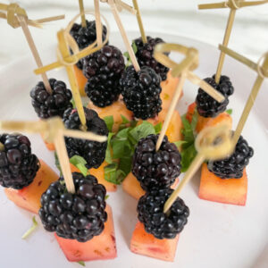 Cantaloupe and blackberries on cocktail picks.
