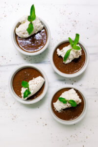 Four Chocolate Pots de Creme garnished with mint and shaved chocolate.