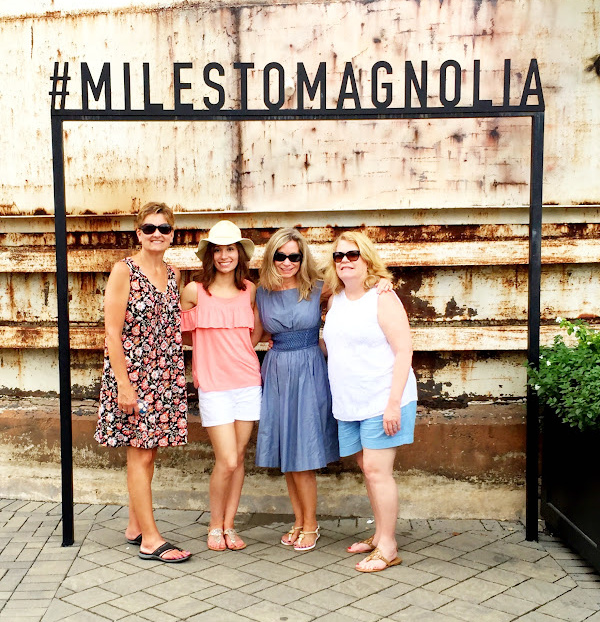 four women standing under Magnolia sign in Waco, Texas.