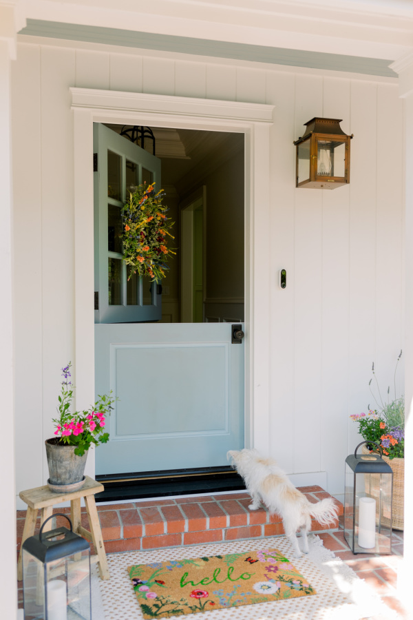 Front porch decorated for spring with dutch door open on top.