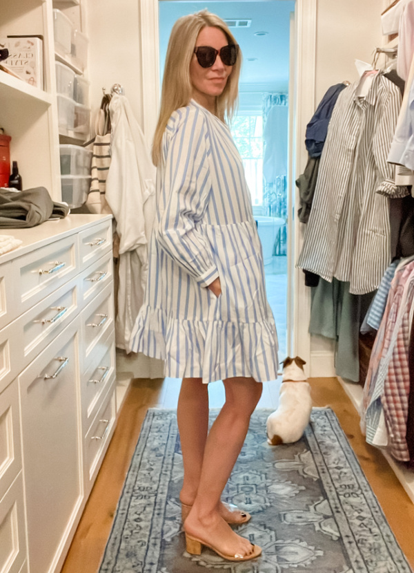 Woman in closet wearing blue and white stripe mini dress.