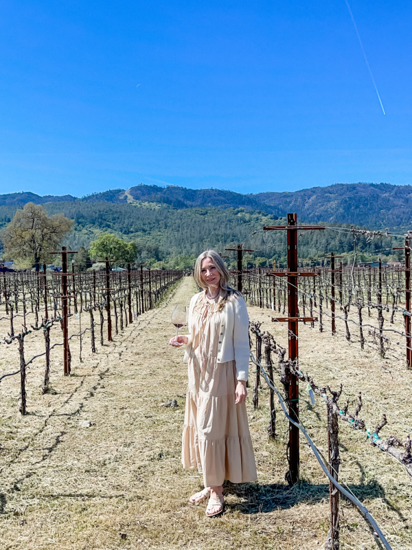 Woman standing in Napa Valley vineyard.