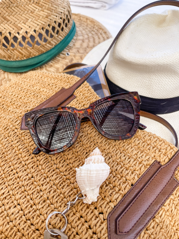 Woven tote, two hats, sunglasses and seashell key ring.