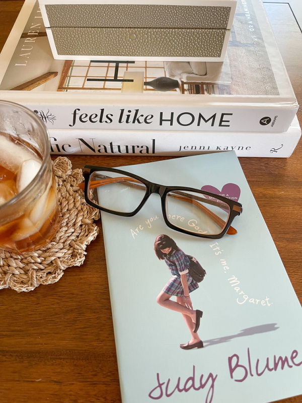 Are you there God It's Me Margaret book sitting on coffee table with reading glasses and glass of tea.