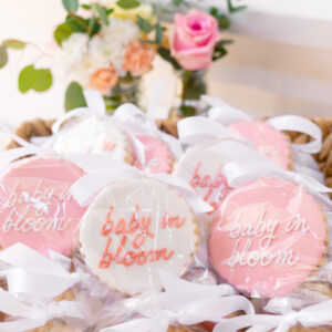 Baby in Bloom cookies wrapped in cellophane and tied with ribbon in a basket.