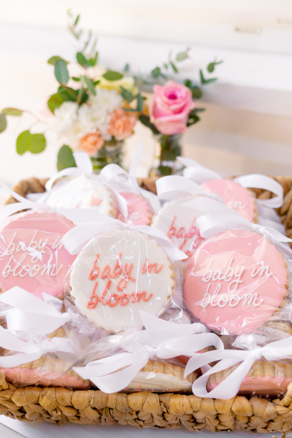 Baby in Bloom cookies wrapped in cellophane and tied with ribbon in a basket.