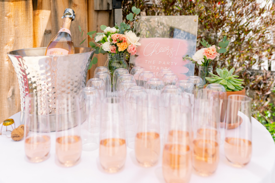 Baby shower welcome table with glasses or rose Prosecco.