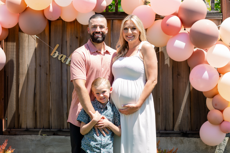 Pregnant couple with their young son at baby shower.