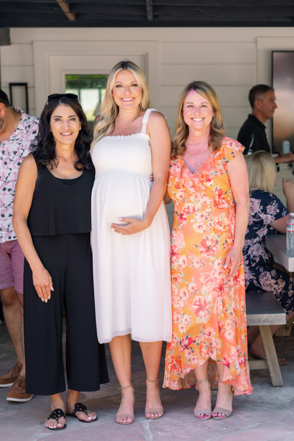 Pregnant mama with her mother and mother in law at baby shower.