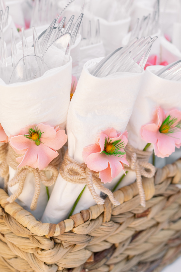 Utensils wrapped in napkins and tied with yarn and faux floral.