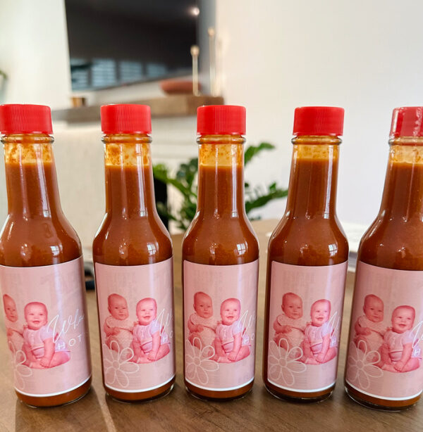 Hot sauced bottles labeled with baby pictures for baby shower.