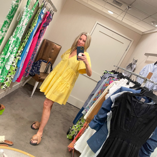Woman wearing A.L.C. yellow dress in Nordstrom dressing room.