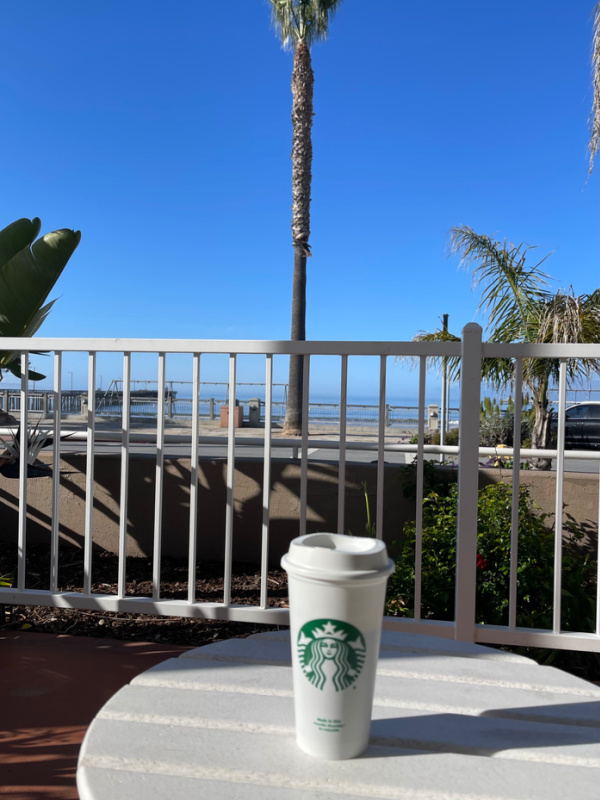 Starbucks cup on hotel patio looking at ocean.