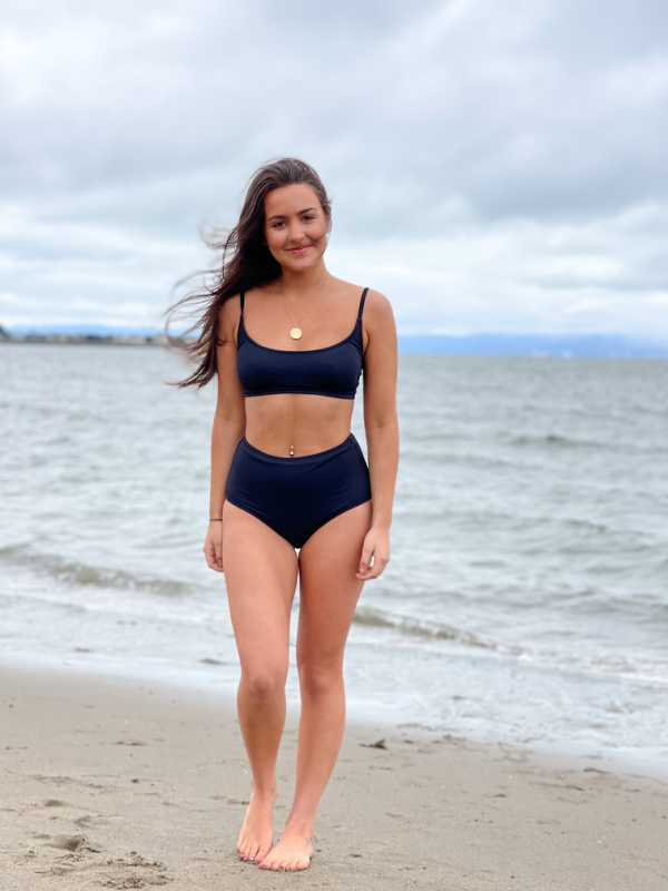 Woman wearing two-piece Change of Scenery swimsuit on beach.