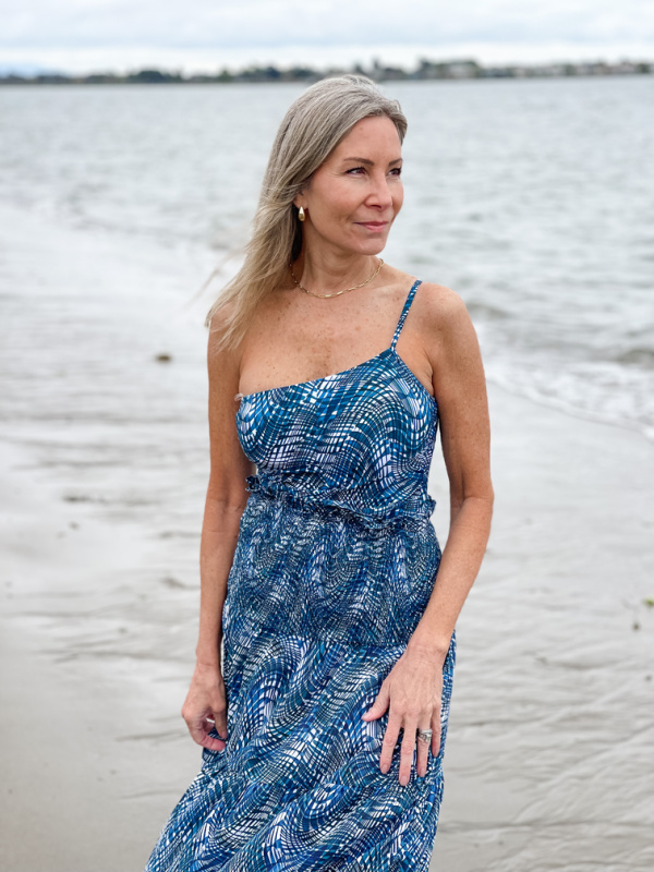 Woman wearing Change of Scenery one-piece bathing suit and matching skirt on beach.