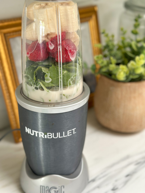 Nutra Bullet filled with makings of a kale strawberry smoothy.