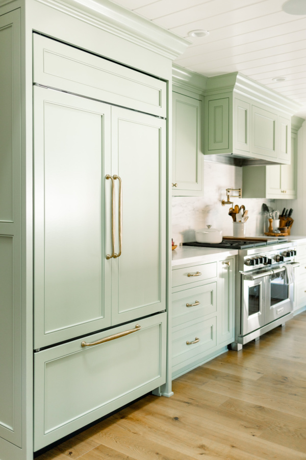 Galley kitchen with green painted cabinets.