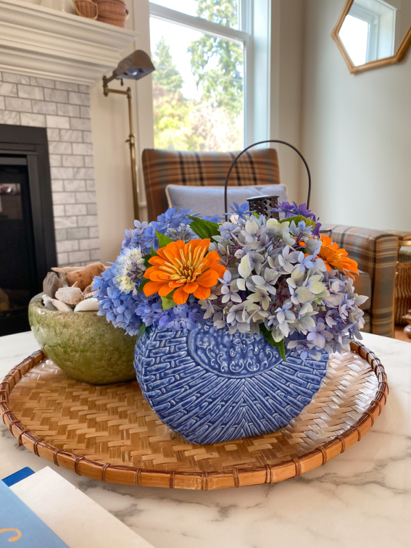 round tray with blue base filled with colorful flowers.
