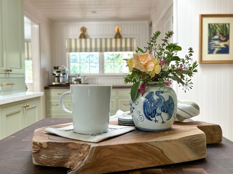 Alice Lane serve board and blue and white ceramic ginger jar filled with flowers in green kitchen.